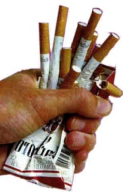 hand crushing pack of cigarettes